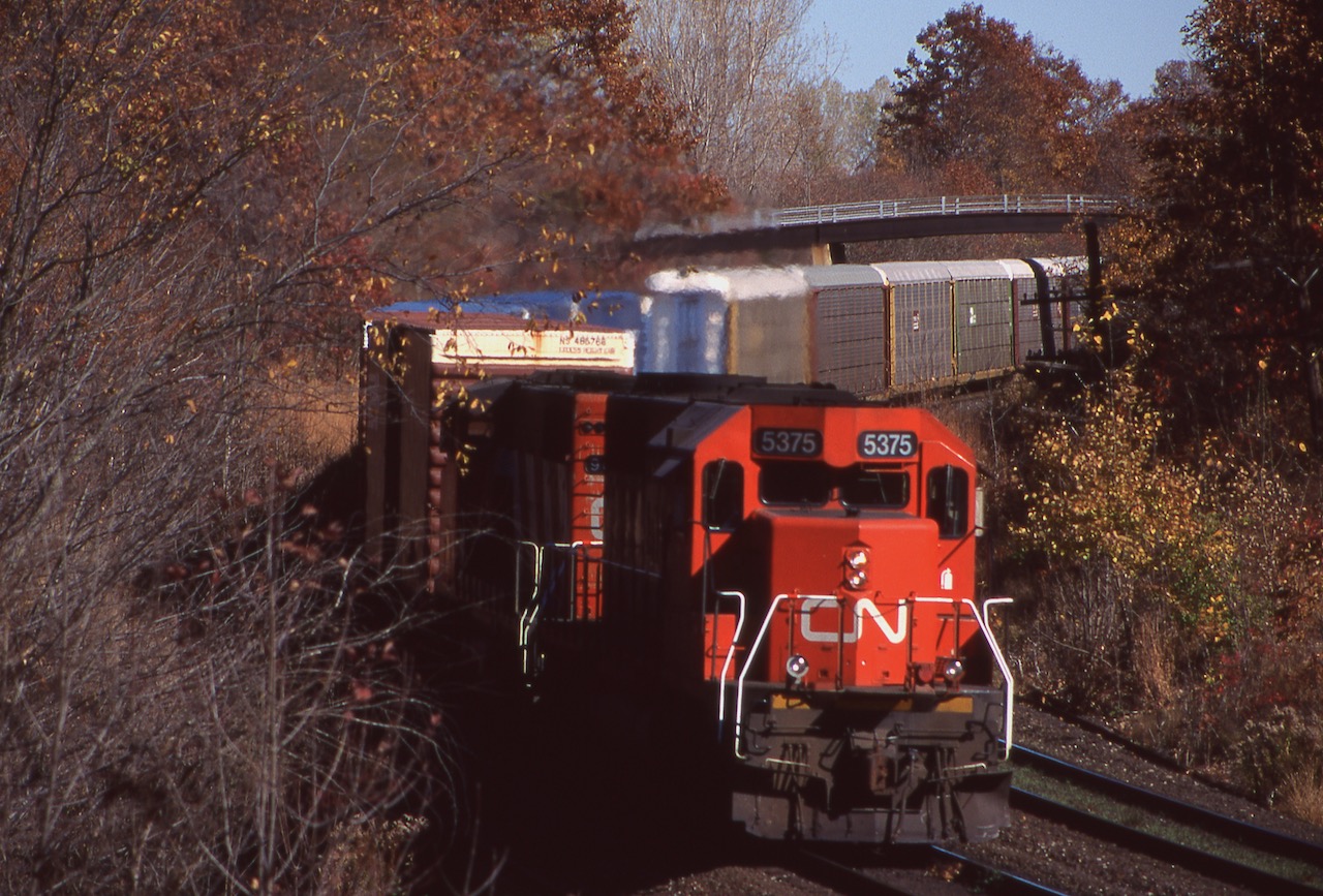 With autumn almost upon us, this scene seemed fitting. It was Halloween day 1998 and the shot at Bayview was much different back then, as a CN former UP/MP SD40 and CN GP40 round the bend at Bayview under fading fall colours with a Niagara bound train.