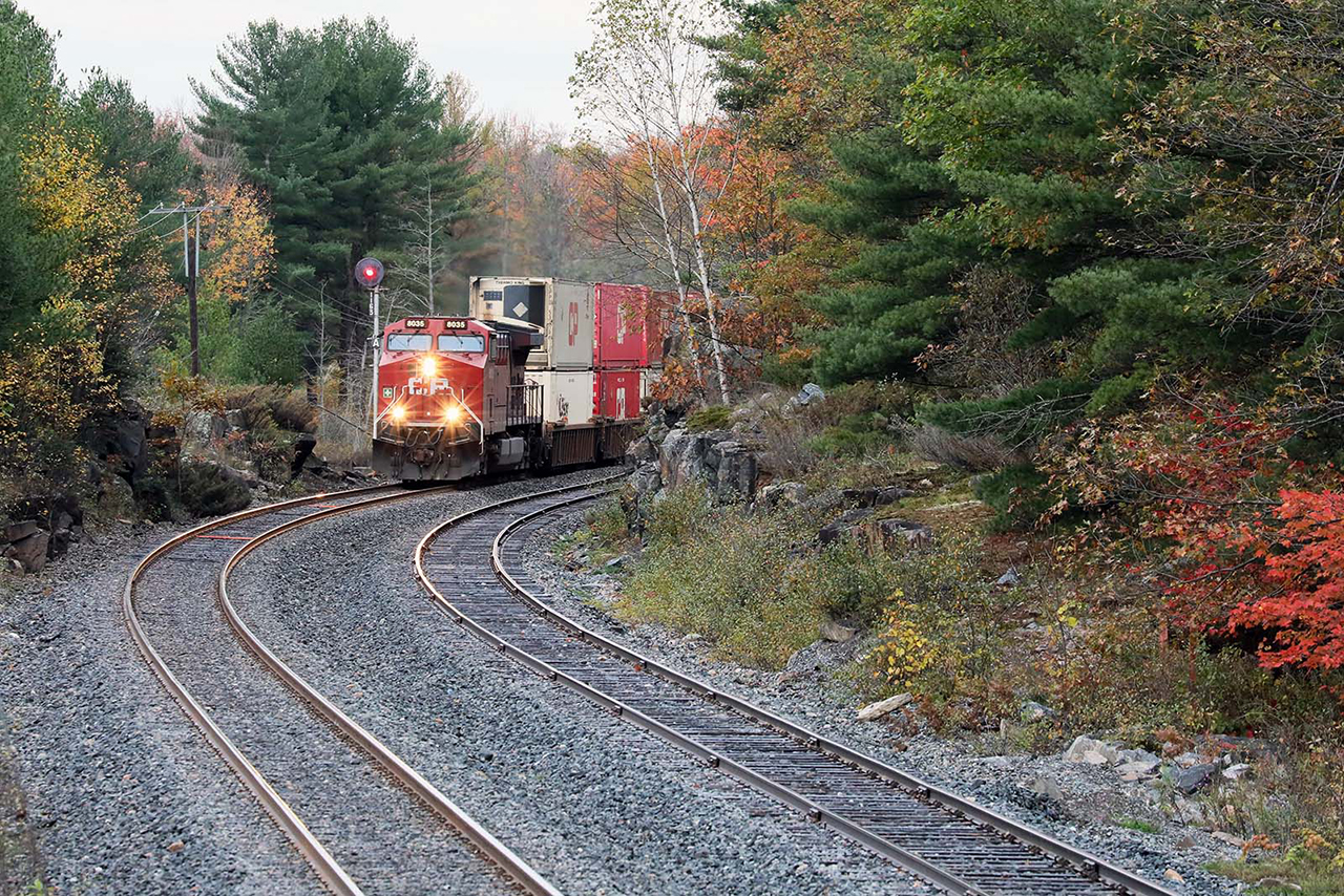 A quintessential Canadian scene. Fall colours, or what is left of them, surround CP 100 as it passes Spiers Lake north of Bala on a cold fall morning. Rocks, trees, and waters are everywhere north of Toronto; beautiful to look at but what a challenge to build a railroad in the 1880's. Outside of the signals and recently replaced welded rail, this is exactly how it looked then....OK, the stacks and GE are a little newer as well.