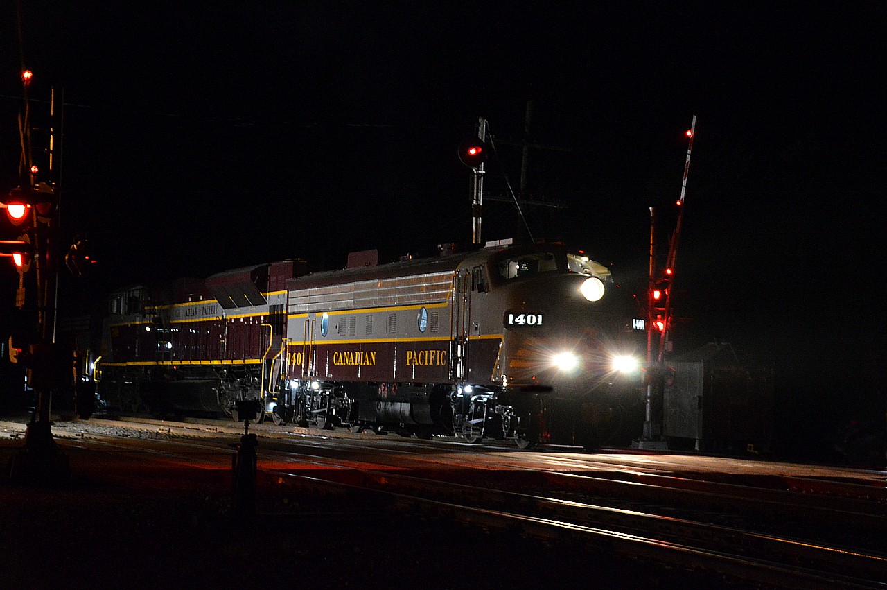 I guess we have seen enough shots of the CP 41B Business Train, but I just had to sneak one more in; as there has to be some reward for waiting 6+ hours for a train that originally was due in at Cartier at 1545 but kept getting thrown back until it finally made the scene at 1950; rather long after dark. So the "plan" was to hang around at the crew change point; bright lights for safety illuminating the scene.  This was the best I could do as the train began to move with the new crew on board and the Spencer Ave crossing lights beginning to activate.
Nice train to see. At least there was some justice for hurrying to this location, taking a motel room 15 km down the way, and settling in for a long wait.  Power is CP 1401, 7019 and 1900, and I think 13 cars.