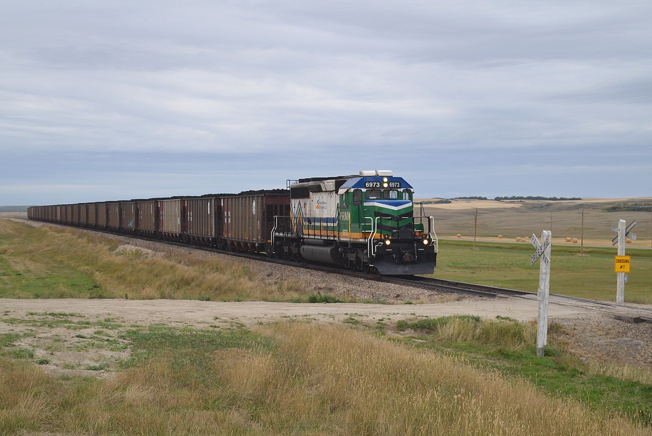 Here's an image of Westmoreland Coal Holdings subsidiary Prairie Mines & Royalty Ltd #6973 making a run with approximately 20 lignite coal loads from the mine to the Poplar River Generating Station; about 20 KM south of the mine and just to the east of the town of Coronach. I understand four round trips a day are made. There are 2 active pits at the mine providing coal to two operating units at the Poplar River station. This is the longest privately owned track in western Canada, but with the current coal contract up in 2029. It is reported Saskatchewan wants out of the coal business by 2030. Then what?  The PRMX SD40-2 was once Ontario Northland 1731 !!