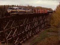 Normally three of NAR’s four SD38-2 units were utilized between McLennan and Roma Jct. on the Peace River grades for which they were ideal, and the fourth cycled between McLennan and Dunvegan Yards in Edmonton.  That is what 401 is doing here, leading GP9 201 westward on the French Creek bridge at mile 81.8 just south of Fawcett at 1243 MDT, with 49 miles to go to a crew change at Smith, then another 131 to reach McLennan.