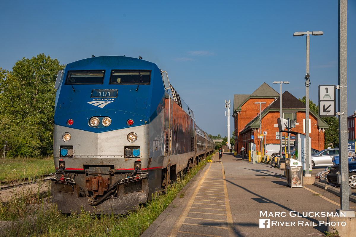 On time in Ontario. Amtrak 63 (Maple Leaf)/ VIA Rail Canada 98 makes the extended station stop for customs and crew change in Niagara Falls, Ontario on the evening of Tuesday, August 28, 2018. Golden hour is just beginning as the train sits next to the station. The depot is a historic treasure, built in Victorian Gothic Revival style station for Great Western Railway in 1879.