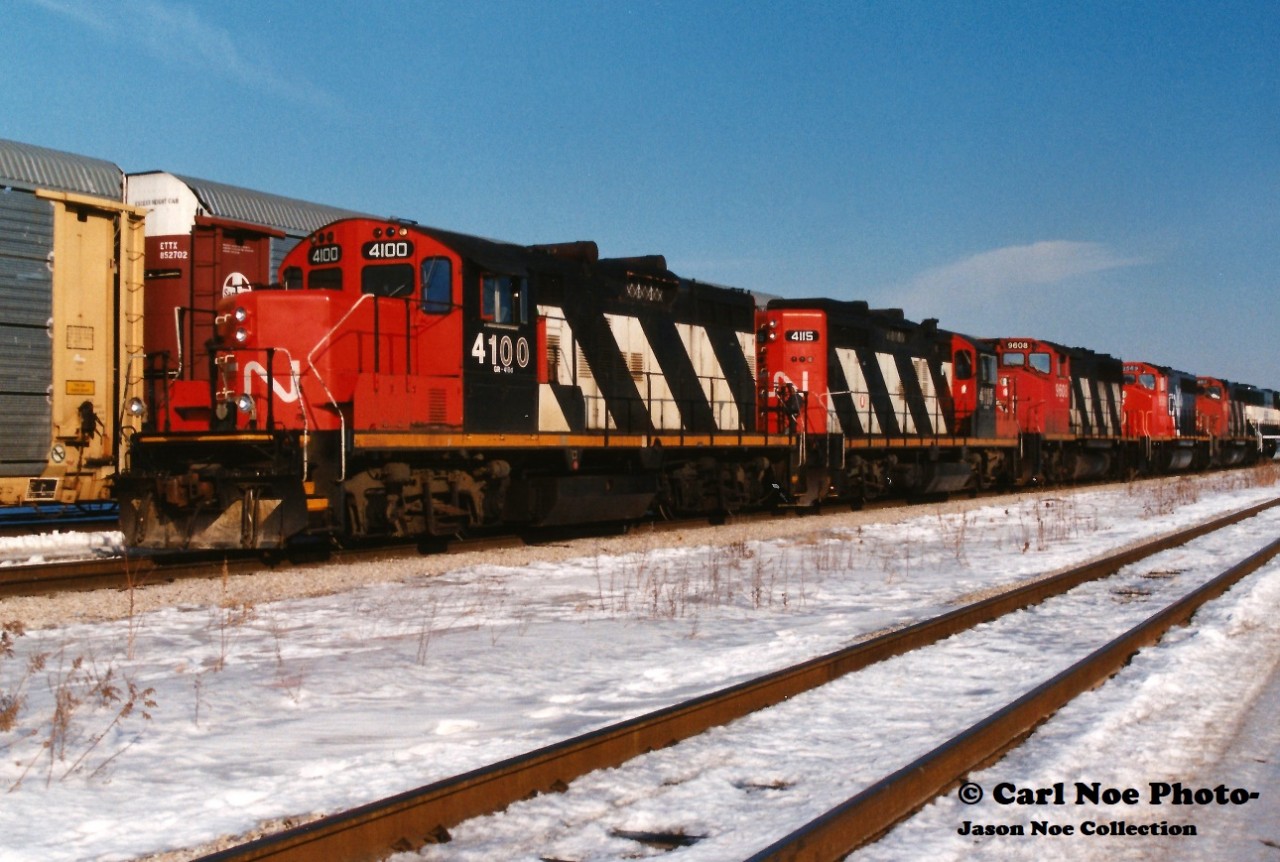 Currently CN 4100 is awaiting a date with K&K’s scrapper’s torch in Welland, Ontario at the former Martech / former Stelpipe facility. Over 26 years earlier it is seen on the point of CN 511 at London about to head westbound to Sarnia on a decent winter day. The consist included; 4100, 4115, 9608, 9569, 9454 and Burlington Northern 9526. At that time, CN was lifting hundreds of newly built BN SD70’s from the GMDD facility in London and forwarding them to BN home rails at Chicago, Illinois.