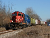 CN GP9RM 7038 leads a lengthy L568 through the village of Petersburg as it heads westbound to Stratford on the Guelph Subdivision.

