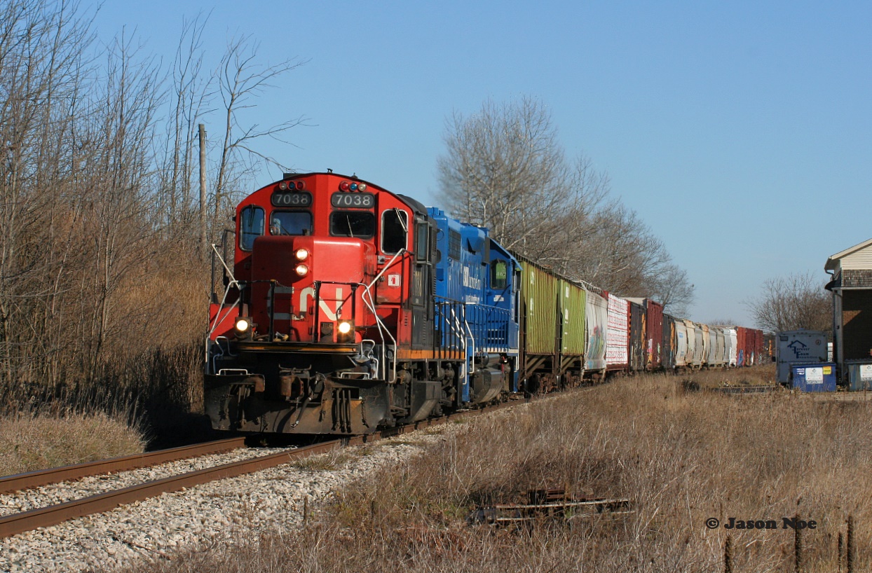 CN GP9RM 7038 leads a lengthy L568 through the village of Petersburg as it heads westbound to Stratford on the Guelph Subdivision.