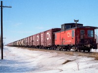 All those cars of grain heading off to be turned into loaves of bread, slices of pizza, tasty cookies . . . There are a few unusual cars in the train. A couple of plug door boxcars and several of the gray coloured CN hoppers make for a little variety from the solid Gov't hopper consists. Up at the front, the 4323 and 4352 are taking the extra home. I see in my notes, I was enjoying my newly purchased film winder the last couple of days. What a difference that made. Shot with Kodak 100asa print film at mile 27.7.