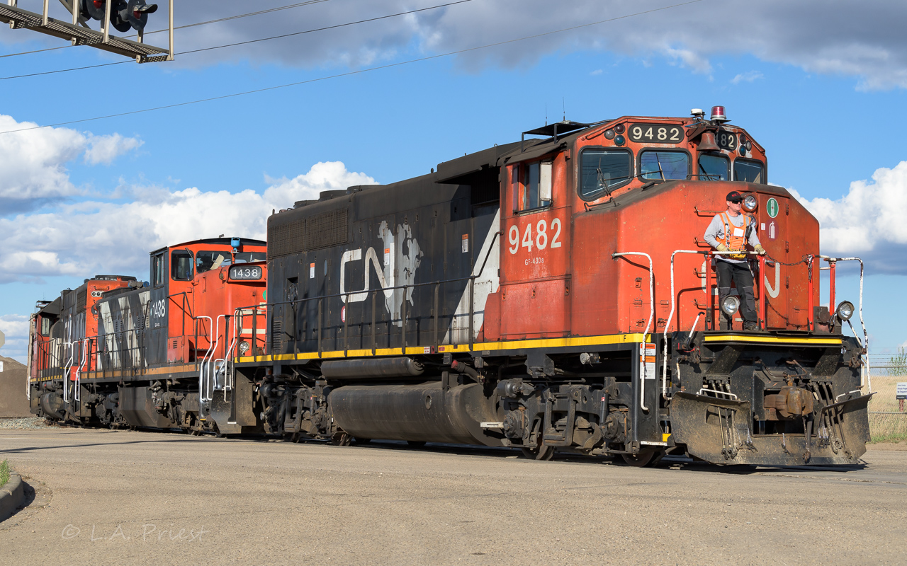 The point man is bringing the units and a cut of cars across 17th street and then onto the Camrose Sub. They are being pulled out of the CN-CP exchange yard located by the Suncor refinery. The crew will make a few more stops going south before running around their train and head north and back to Clover Bar. Sporty blue bell on the 1438.