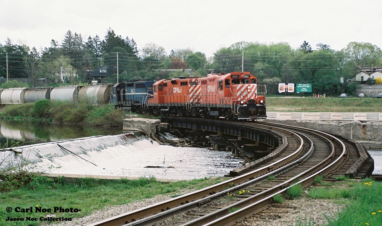 Back when cheeseburgers were 89 cents, the CP Galt day job slowly crosses the Speed River in Preston, Ontario on the Waterloo Subdivision with 1508, 8247 and HLCX 4203 during spring 1998. The hoppers on the head-end were destined for the interchange with CN at South Junction in Kitchener.