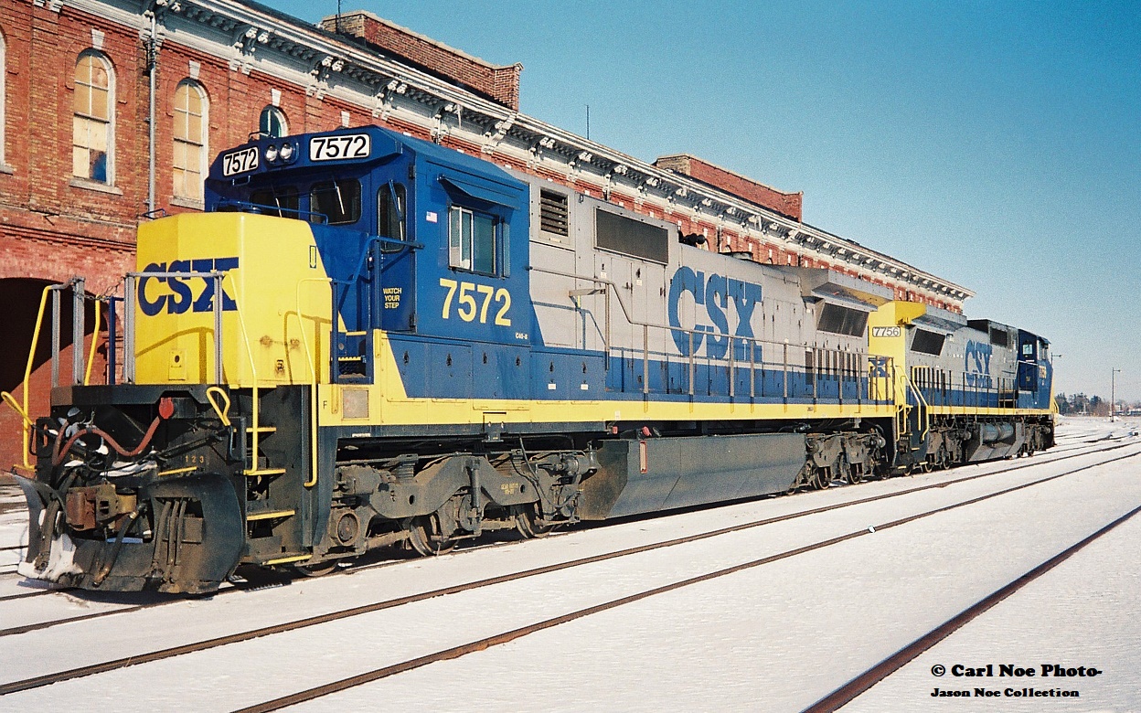 By early 1994, the Railway Capital of Canada was a far cry from its former glory days, however compared to today St. Thomas was still actually an active city as far as being served by different railroads. Long gone were the days of Conrail, Chessie and any passenger trains, however CSX, NS, CN and CP trains still converged on the city. CSX was still operating across the CASO Subdivision, however not for much longer, while NS still ran dedicated auto parts trains on the Cayuga and Paynes Subdivisions, although that window was shortly closing too. In nearby Talbotville, CN served the huge Ford assembly plant and had a large yard with several assignments based, including serving industries on the Cayuga Subdivision. Also, CP came into the city regularly on their St. Thomas Subdivision.

Here on an incredibly cold but sunny winter afternoon, CSX 7572 and 7756 are viewed idling beside the historic Canada Southern Railway station. This power was likely off CSX R320, which would tie-down here and not continue to Buffalo. Eventually it would become R321 simply departing St Thomas then it would ‘cab hop’ to Fargo, where it would lift all the traffic off the North end and continue to Windsor and Detroit.