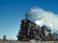 About halfway through it's 166.3 mile journey, CNR J-4-e Pacific 5126 (MLW June, 1920) hustles daily except Sunday train 173 along just north of Drayton approaching the crossing of Wellington Road 8.  Having departed Hamilton James Street Station at 0550h, the train is due at Palmerston at 1103h, departing at 1120h for the final leg of the journey to Owen Sound, arriving at 1345h.  With a scheduled stop at <a href=https://d10j3mvrs1suex.cloudfront.net/u/131959/bd4f9a59ec0a823683e6e1b57826f5d6504ebd1a/photo/drayton-gtr-ex-wgb-1921-ross-gray-coll.jpg/!!/meta%3AeyJzcmNCdWNrZXQiOiJjb250ZW50LnNpdGV6b29nbGUuY29tIn0%3D.jpg>Drayton station</a> at 1042h, we can reasonably presume it is about 1050h at the time of this photo.  5126 would be scrapped in February 1960.<br><br><i>Original Photographer Unknown, Al Chione Duplicate, Jacob Patterson Collection Slide.</i>