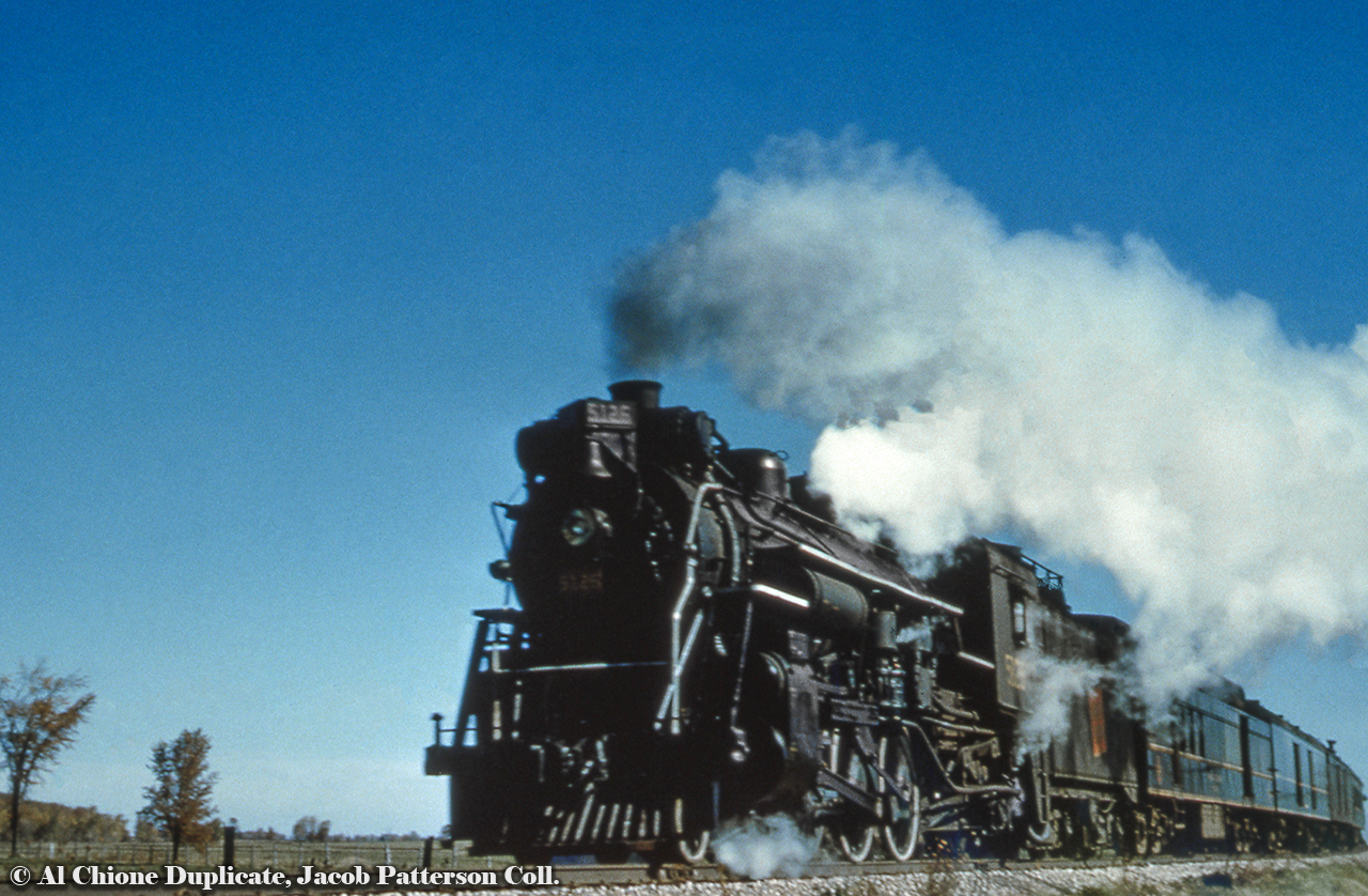 About halfway through it's 166.3 mile journey, CNR J-4-e Pacific 5126 (MLW June, 1920) hustles daily except Sunday train 173 along just north of Drayton approaching the crossing of Wellington Road 8.  Having departed Hamilton James Street Station at 0550h, the train is due at Palmerston at 1103h, departing at 1120h for the final leg of the journey to Owen Sound, arriving at 1345h.  With a scheduled stop at Drayton station at 1042h, we can reasonably presume it is about 1050h at the time of this photo.  5126 would be scrapped in February 1960.Original Photographer Unknown, Al Chione Duplicate, Jacob Patterson Collection Slide.