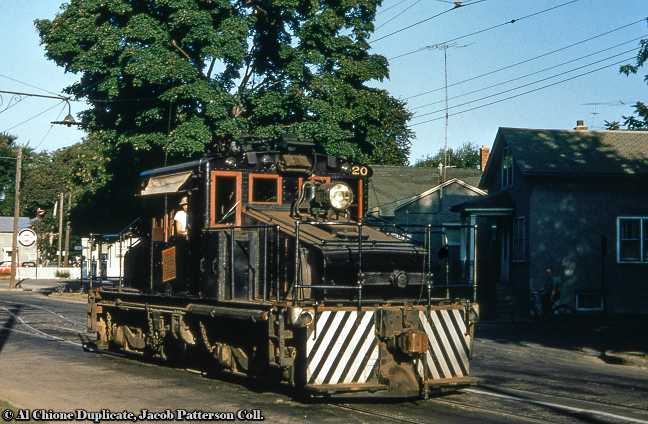 NS&T motor 20 heads eastbound down Welland Avenue in St. Catharines from the Welland Avenue car barns just to the west of this location (today the Midtown Plaza).  Note the double track and crossover behind the motor, which ran from the the barns to a point just west of Geneva Street before becoming single track.  The Regent gas station at the corner of Francis Street and Welland Avenue is today Gales gas station.NS&T 20 was built by GE in March 1914 as South Brooklyn Railway number 6.  It was sold to the Charleroi and West Side Street Railway of Pittsburg in December 1917, and then to the NS&T in 1937. It was scrapped in 1960.Original Photographer Unknown, Al Chione Duplicate, Jacob Patterson Collection Slide.