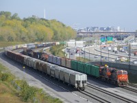 CN 305 has lumber and aluminum up front as it approaches the crew change spot of Turcot Ouest with CN 2280 & CN 2648 for power.