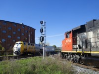VIA 24 with VIA 911 and a HEP/LRC consist is passing CN 4795 on the CN East Side Canal Bank Spur. The Pointe St-Charles is about to accept a Slow to Stop signal and temporarily enter the main line for headroom, before backing on to the Spur.