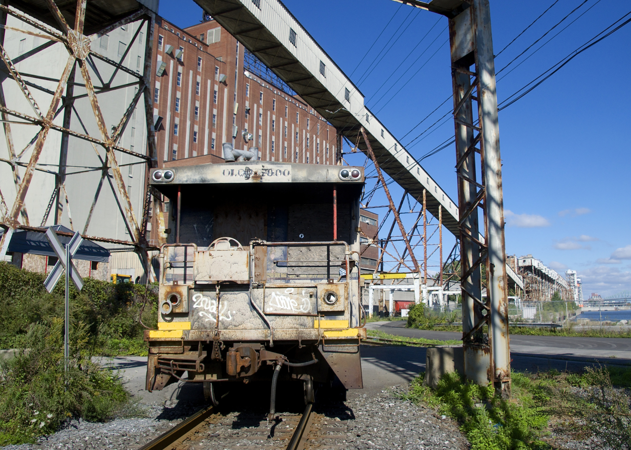 The Pointe St-Charles Switcher's beat-up shoving platform has been left on the CN Wharf Spur as they switch Canada Maltage and Five Roses. The Five Roses facility is visible at left.