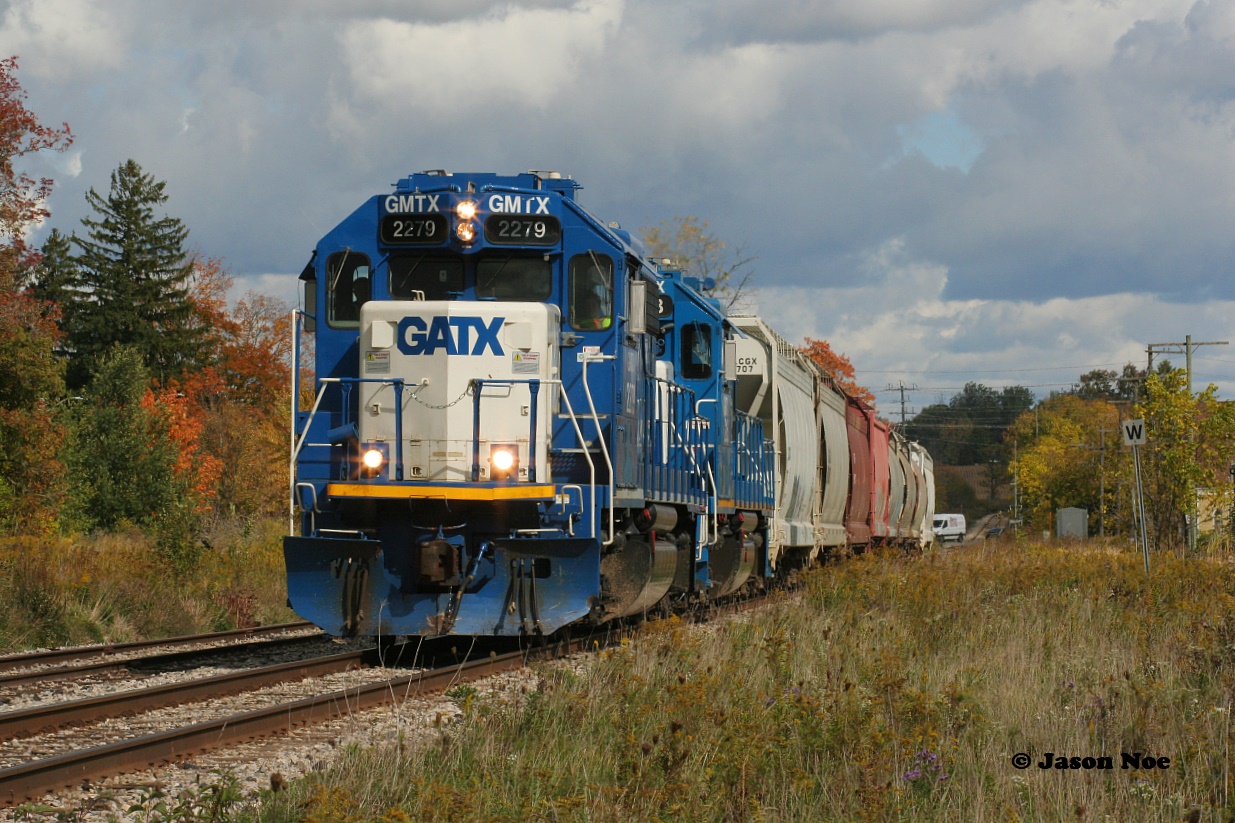 Two blue GMTX's catch a gift sunny break amongst the clouds and a splash of fall colors during my birthday last year as they lead CN L568 through Baden westbound on the Guelph Subdivision.