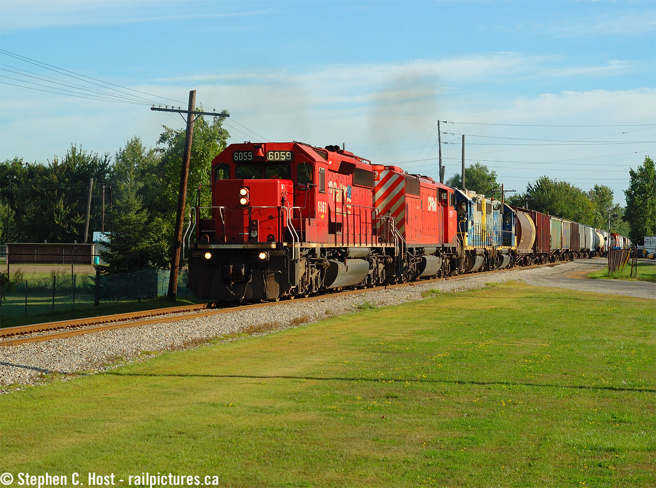 With about 80 cars on the drawbar, CSXT D725 is finally underway southbound to Chatham rolling between the Baseball fields of Corunna. The CSX power trailing the CP SD40-2F will be used on a Chatham-Blenheim-Sarnia D724 in the afternoon, shortly after arrival of this train in Chatham around 1300. It was a slow journey from Sarnia to Chatham, about 7-8 hours after the crew got on duty in Sarnia and usually meant there was a new crew needed for the northbound journey.
Here's an audio link recordedthis day. Detector at Mile 51 (Note 86 cars, subtract the engines for the total car count.. and what about that blistering speed.. )