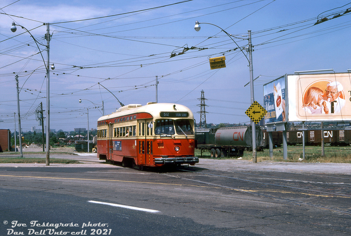 Pulling out of the old Keele Loop, TTC PCC 4514 (one of the A8-class PCC cars built by CC&F in 1951, the last new PCC's purchased by the TTC) on the Rt.512 St. Clair enters Weston Road for the shot jaunt to St. Clair, where she will turn and head east bound for the Spadina Line's St. Clair West Subway Station (short turning, as per the front flap turned up). A this time, the old Keele Loop was on borrowed time, with the new Maybank (Gunns) Loop further west on St. Clair opening a year later. Advertising billboards push Rothman's Special Mild cigarettes, and Kentucky Fried Chicken featuring Colonel Sanders (who apparently lived in nearby suburban Mississauga in his final years).  In the background are CN's old West Toronto freight yards, for years often full of livestock cars and reefers to serve the nearby meat packing industry. As time went on and a lot of that industry closed up or moved out, the yards fell out of use in the late 80's and were removed. The empty land was eventually redeveloped into townhouses in the early 2000's.  Joe Testagrose photo, Dan Dell'Unto collection slide.