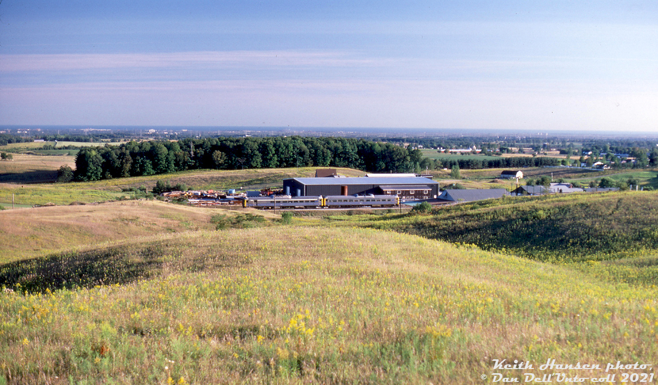 The late Keith Hansen covered a lot of territory east of Toronto, including many of the CN and CP branchlines in their waning years. Operation on the CP's Havelock Sub were included, home to some of the last branchline passenger runs in Southern Ontario served by Budd RDC cars (before the January 1990 service cuts nixed them). Here, a VIA RDC-2 and RDC-1 (likely units 6224 and 6121) make their way eastbound through Raglan, Ontario on Toronto-Havelock train #192 after crossing Simcoe Street North (out of frame to the right). This view is from the Purple Woods Conservation Area, looking south to Raglan, and beyond to Oshawa and Lake Ontario off in the distance.

Keith Hansen photo, Dan Dell'Unto slide collection.