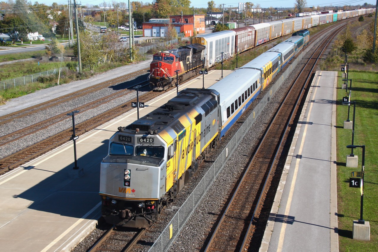 A perfect late autumn day in Belleville, Ontario where the rail paint schemes vary like the leaves, but we enjoy them all. VIA Rail train 63 is pulling in to the station just a few minutes behind schedule. 63 is lead by F40PH-2, 6420 and trailing is P42DC, 901. Waiting to proceed out of the yard with a long string of auto racks is ES44AC, CN 3090, looking a little worse for wear.