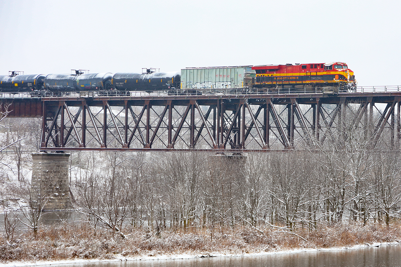 A look at the future. A healthy delay between Woodstock and Galt gave us a KCS leader in daylight...and the snow. Fortunately, it had abated significantly by the time 650 arrived at the Grand River...this shot following Bill Miller's mantra that for something to be a true oddity, photograph it in a location that shows how abnormal it is. 

650 crosses the Grand River with 8063 pushing at 0935, Nov 30.