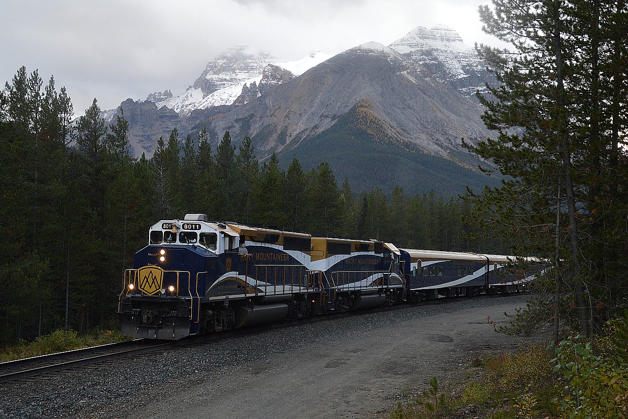 Well, with me; I know a train is coming when the skies turn dark.  Just my luck.  I'm on Lake O'Hara Road; maybe 2 miles west of the Alberta border and a dozen miles east of Field.  I knew the Rocky Mountaineer was on its' way; waited while it navigated the Spiral Tunnel, and was rather disillusioned when the skies turned dark.  Thats the way it goes. RMRX 8011 and 8018 power this eastbound in the late afternoon; destination Banff. The mountains gave this location a nice setting for a photo.