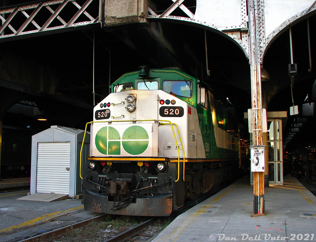 When F59PH's still ruled the roost in downtown Toronto: GO Transit F59PH 520, the first F59PH unit build by GMDD London (Serial A-4745, Glass GCE-430G, Build date 09-88, as per its builder's plate checked that same morning) sits poking out of the 1920's-era "Bush" style train shed at Union Station during morning golden hour, having just arrived nearly half an hour late off Georgetown line train #206 on Track 7. A nice little artifact was that wooden TTR telephone box on one of the poles. Two tracks over, VIA's #1 "The Canadian" sits on Track 9 awaiting its 9am departure for Vancouver.  An all-too familiar story to anyone commuting precedes this photo: I had caught the morning GO bus hoping to catch morning Georgetown line train #208 at Bramalea at 7:30am, which runs express to downtown Toronto arriving at 7:56am. Usually the bus-train connection was seamless, but it turned out there was extra road traffic enroute and the bus arrived at Bramalea late at 7:35. Well, things were also delayed on the Georgetown line that morning, and earlier train #206 (supposed to depart Bramalea at 7:15, but running 20 minutes late) and #208 (7:30 dep) were both running behind. So we hopped on the first crowded train going downtown, which happened to be #206 with 520 leading, making all stops with trains #270 (7:40 departure) and #208 both following down the single-track Weston Sub from Bramalea to Union. Arrival time at Union was a good 27 minutes late for #206 (normally 7:48, today 8:15) as seen here, and some of the commuters late for work are doing a GO Transit no-no of crossing the tracks at platform level, using the adjacent platform's less-crowded narrow staircase down to the old GO concourse. Just another one of those mornings.