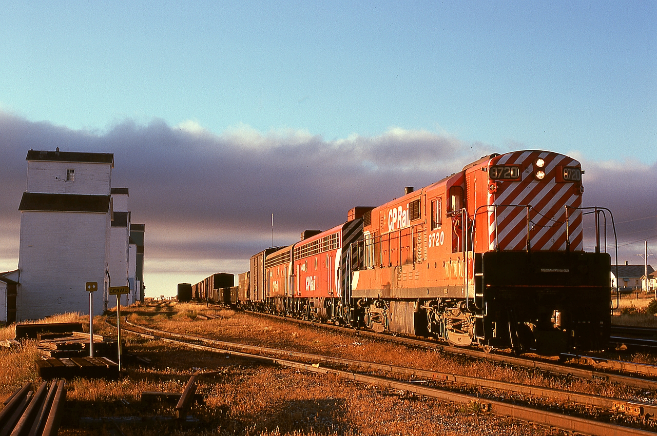 On the cold morning of Thursday 1974-10-03 at Aldersyde, AB, train Second 75 with FM/CLC H16-44 8720 leading and GMD F7B units 4433 and 4444 trailing has paused at the depot (the mast seen above the first boxcar is for the radio at the depot) for a meet with southward train 992.  No. 75 was a daily train from Lethbridge via the Aldersyde sub. to a junction with the Macleod sub. (near the tail end of this train) and onward to Alyth Yard in Calgary.  Now, the Macleod sub south of Aldersyde is history except for a short spur, and north of here is a continuation of the Aldersyde sub.