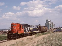 After the 1981-01-01 takeover by CN of Northern Alberta Railways, NAR power was renumbered into the CN series, then later the Northern Alberta lettering and diamond symbols were blacked out, and eventually (typically coinciding with overhauls) full CN paint was applied.  One full and one partial remarking are shown here, 4602 the former NAR 201 and 4606 formerly NAR 205.  Spirit River is at the very west end of the CN Smoky subdivision, five miles west of a junction at Rycroft where most traffic runs south to Grande Prairie, and the five-mile stretch is utilized now for car storage.  The crossing in the photo is 52 Street, and the grain elevators and trackage seen here are now history for five blocks east, all blank to 47 Street.