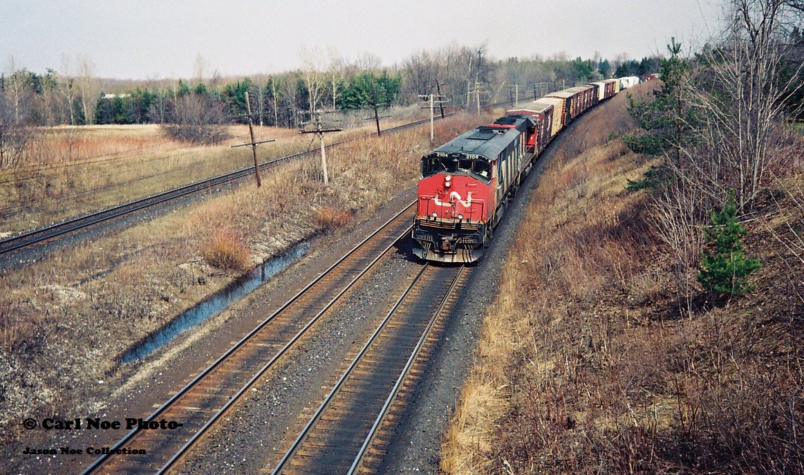 CN 381 is seen westbound as it wastes no time heading for Windsor approaching the famed Denfield Road bridge at Hyde Park with CN 2104 and 5041.