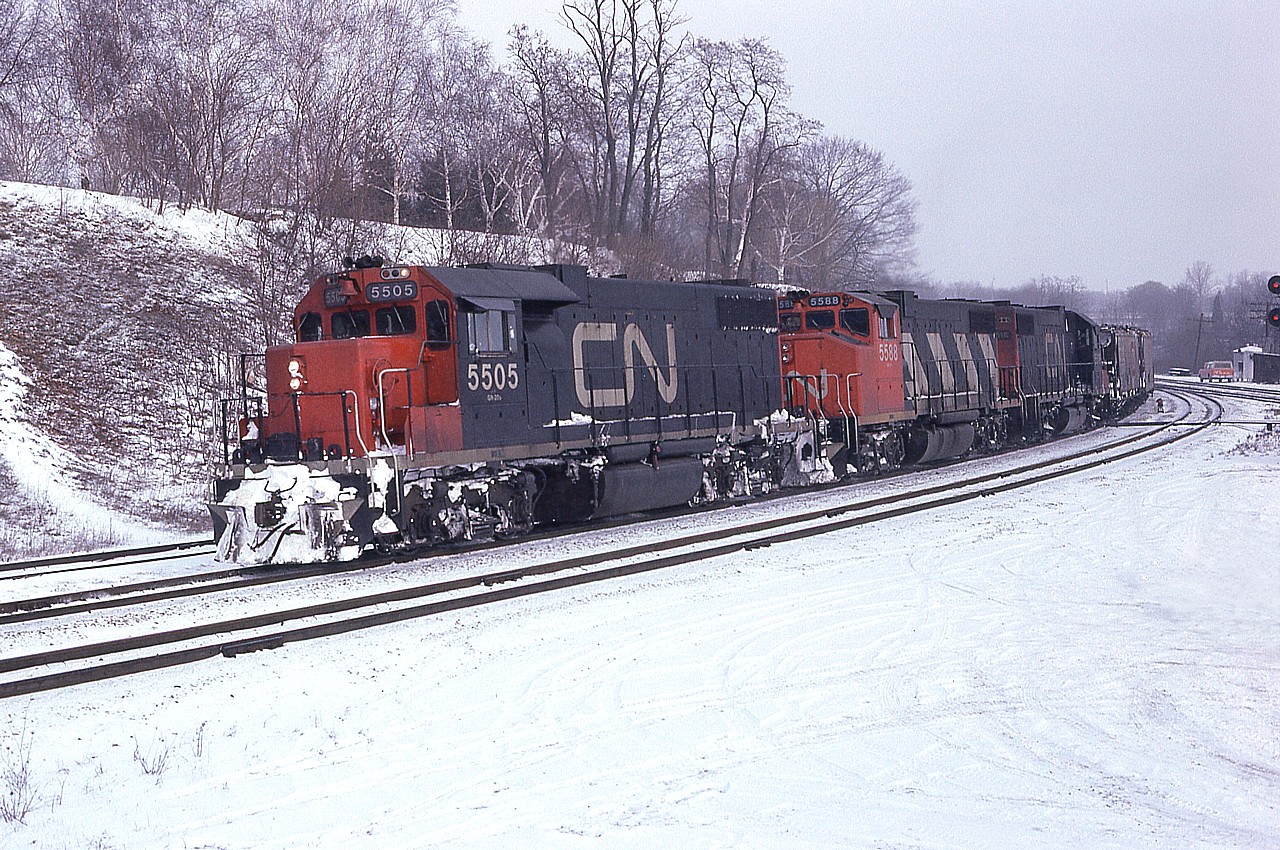 Winter is coming!!! I find it hard to believe enough years have passed that there has been, since this image, a whole new series of 5500s (SD60s) and even they have been retired from the CN roster.  In this photo, on an obviously cold winters' day; CN 5505, 5588 and 5516 are heading westward toward London and I am sure I waited for them within the confines of my warm car.......as we could park in the Jct area back then.  This series of 5500 GP38-2s were renumbered into CN 4700s in 1988. Note the middle unit is a wide cab. The far track is an old  helper track; a relic from the Steam Era where helpers waited to assist trains up the long Copetown grade. It has long since been removed.