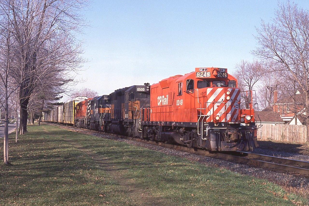 Rolling along, Toronto-bound; CP #523 is photographed by Palmer Av in Niagara Falls; about 2 minutes from fouling up all the traffic around Clifton Hill. This used to drive the city nuts. Seventy car trains running at about 10 MPH caused terrible bottlenecks.  But, in the end, the city won out and by December 2001 the trains were gone and the track was eventually pulled up. This late day train is pulled by CP 8249, HLCX 6500, HATX 506 and CP 5582.