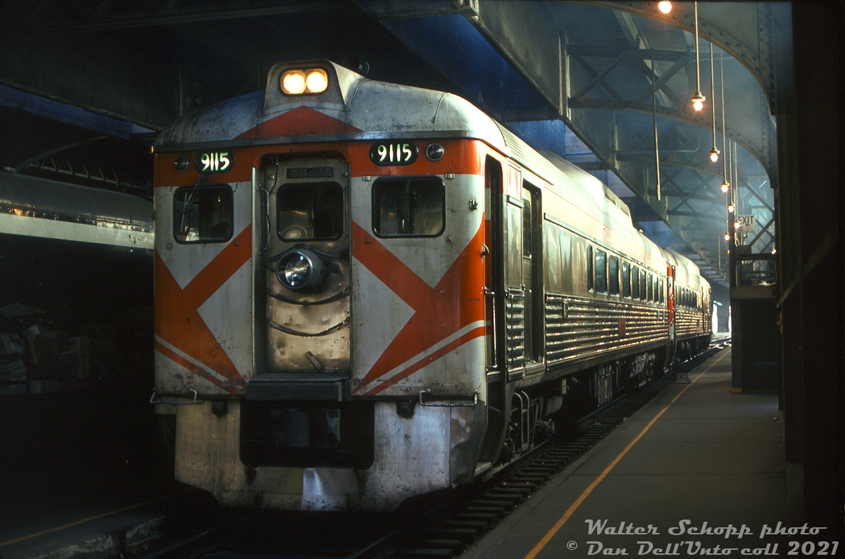 CP Budd RDC-2 car 9115 sits on Track 10 under Toronto's Union Station train shed with an RDC-3 on CP train #321, the old TH&B Budd run between Toronto and Buffalo NY (via Hamilton and Fort Erie). Note the large Gyralite hung from the front door, a safety feature comparable to modern ditch lights that CP adopted on the lead RDC of all of its "Dayliner" runs since the mid-50's (yes, a crewmember had to disconnect and drag it to mount on the opposite end of the train at the end of every run).By this time, CP's John Street roundhouse downtown wasn't the hoppin' passenger servicing facility it was during its peak, and only serviced a few CP passenger trains: the Toronto-Sudbury sections of The Canadian (#11/12), as well as maintaining around half a dozen Budd RDC cars for the Toronto-Havelock and Toronto-Buffalo "Dayliner" runs. For the latter train in this photo, two units appear to have been the norm in the 70's, usually an RDC-2 and RDC-3 together, sometimes a pair of either model, and sometimes a baggage-only RDC-4 was substituted for one of the normal pair. A few cars including 9020, 9063 and 9115 were John Street regulars for many years, and given the year that's likely 9020 trailing 9115 in this consist.The TH&B Budd run continued into the VIA era, until its final run on April 25th 1981 (see Mr. Mooney's photo of the last run), coinciding with the first run of Amtrak/VIA's new Maple Leaf the next day.Walter Schopp photo, Dan Dell'Unto collection slide.