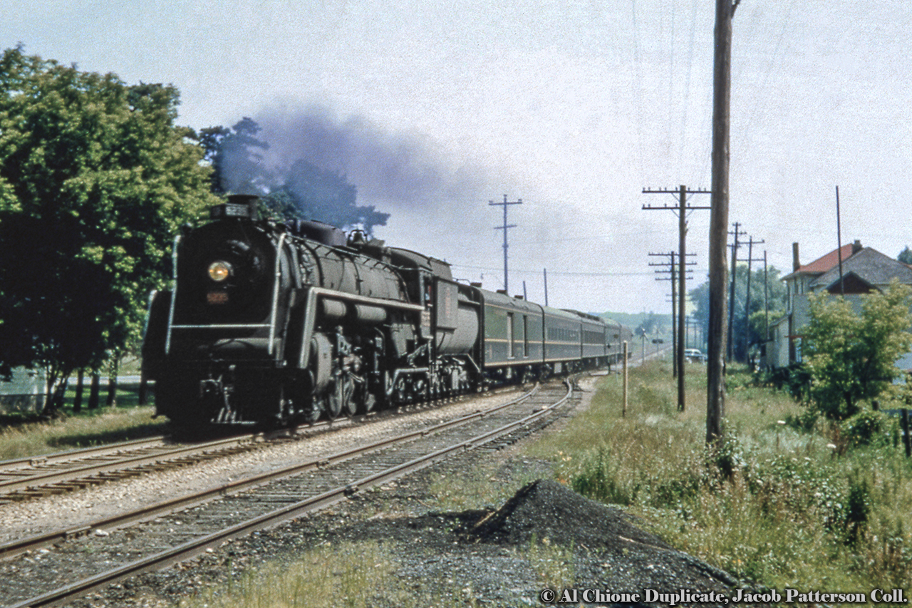 At 1018h, Train 29 barrels through Baden behind U-2-h 6235 about halfway through its Toronto - London trip.  Built in July 1943 by MLW as the first of 30 U-2-h locomotives ordered by the CNR, 6235 would be scrapped in July 1961.  Note the yellow, wooden derail post and the mix of crossing protection styles at the Snyder's Road (old Highway 7 and Foundry Street intersection (some wooden, some lights and bells).  Original Photographer Unknown, Al Chione Duplicate, Jacob Patterson Collection Slide.