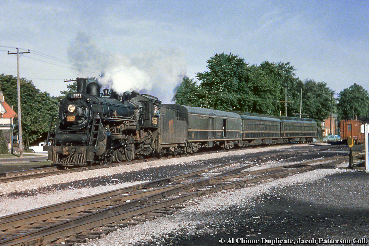 Due into Stratford at 0705h, train 28 from Goderich is seen curving down the last piece of the Goderich Sub alongside St. David Street (house at left being number 57) and, out of sight to the right, the CNr Stratford shops (note the sign and switchstand in both images).  In just a moment, 28 will pull into track one and 5567 will head for the roundhouse to be serviced.  A heavier engine, likely a Mountain type, will take control from Stratford to Toronto as the consist will grow with two coaches tacked on the rear.  28 will depart for Toronto at 0717h, arriving at 0950h.CNR 5567, a K-3-a Pacific built by the Grand Trunk in 1912 as P4 class number 231.  It received its renumbering/classification in 1923, and was scrapped in May 1958.  As such, this undated slide would likely have been taken in 1957 or earlier.Original Photographer Unknown, Al Chione Duplicate, Jacob Patterson Collection Slide.