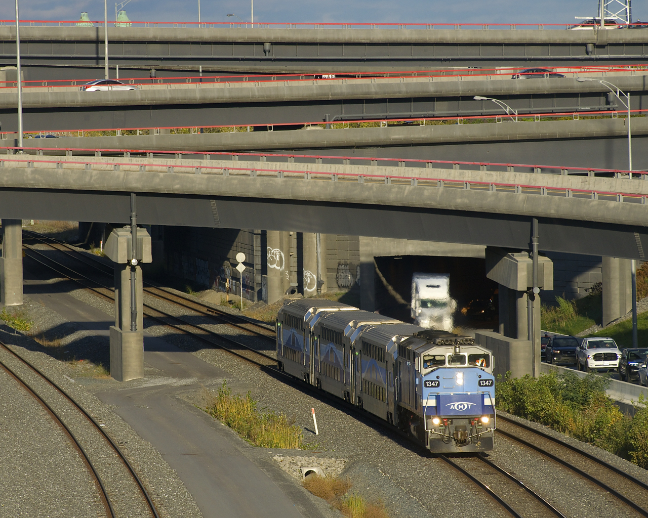 The first departure of the afternoon from Central Station for Mascouche has just passed under the Turcot Interchange with AMT 1347 and three multilevel cars.