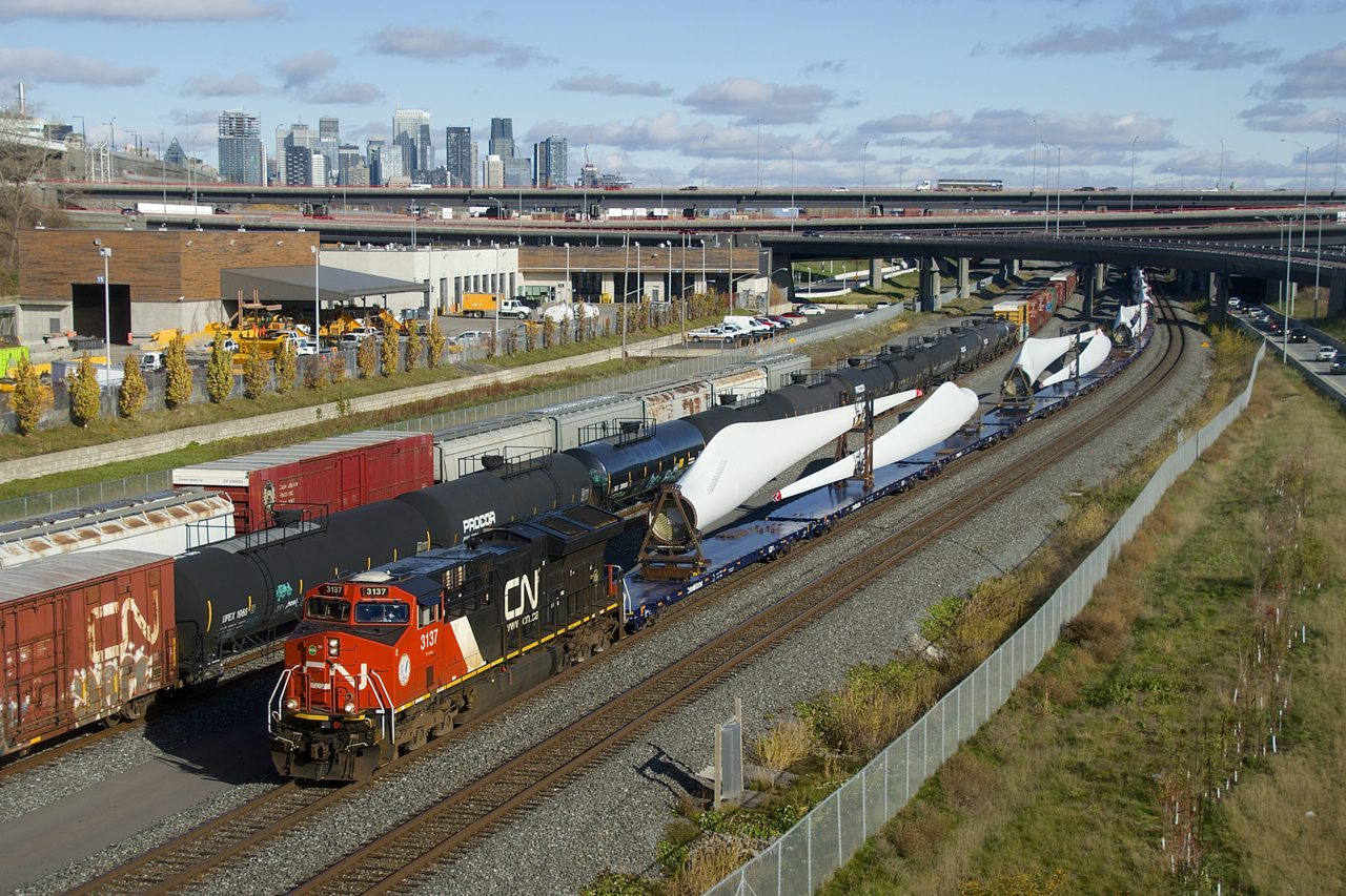 Windmill train CN X319 passes cars parked on two tracks as it approaches Turcot Ouest to change crews.