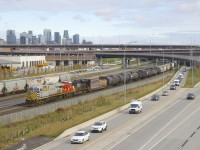 ES44AC's in two paint schemes (CN 3957 & CN 3899) lead CN 309 past the skyline of downtown Montreal.