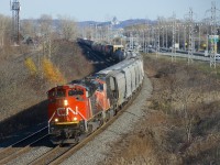 An SD70M-2 and an SD75I (CN 8874 & CN 5762) lead a CN 377 with grain empties up front through Beaconsfield.