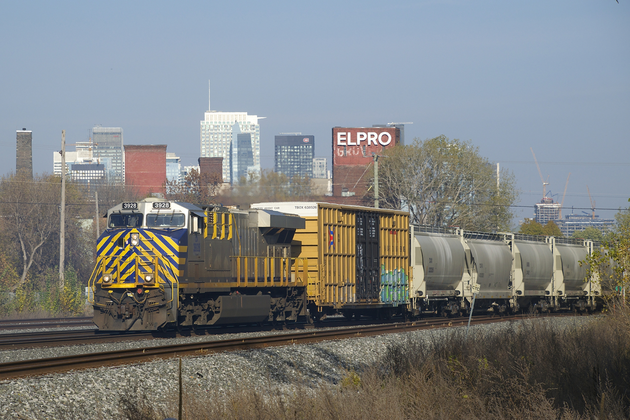 Ex-Citirail CN 3928 leads CN 305 past the skyline of downtown Montreal.
