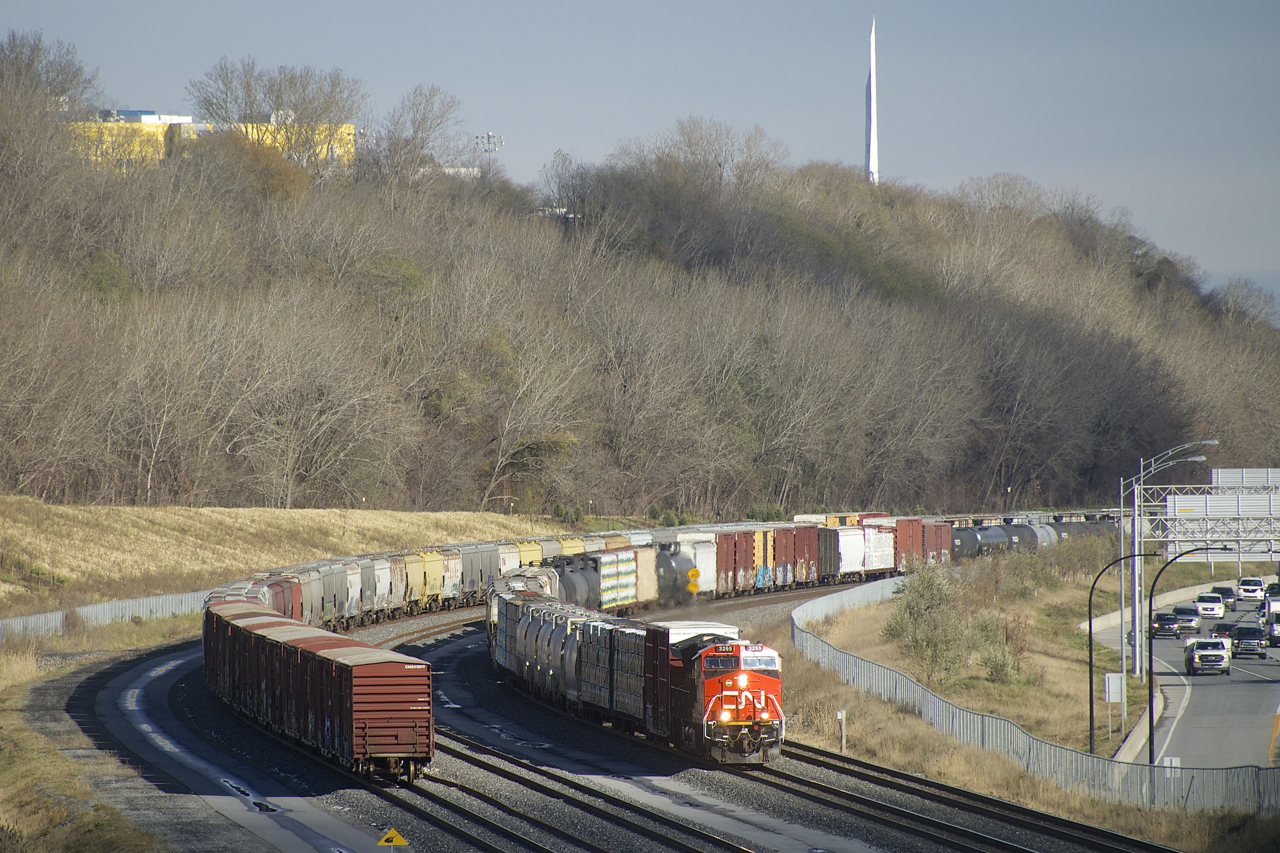 CN 305 rounds a curve as it passes cars parked on Track 29 of the Montreal Sub.