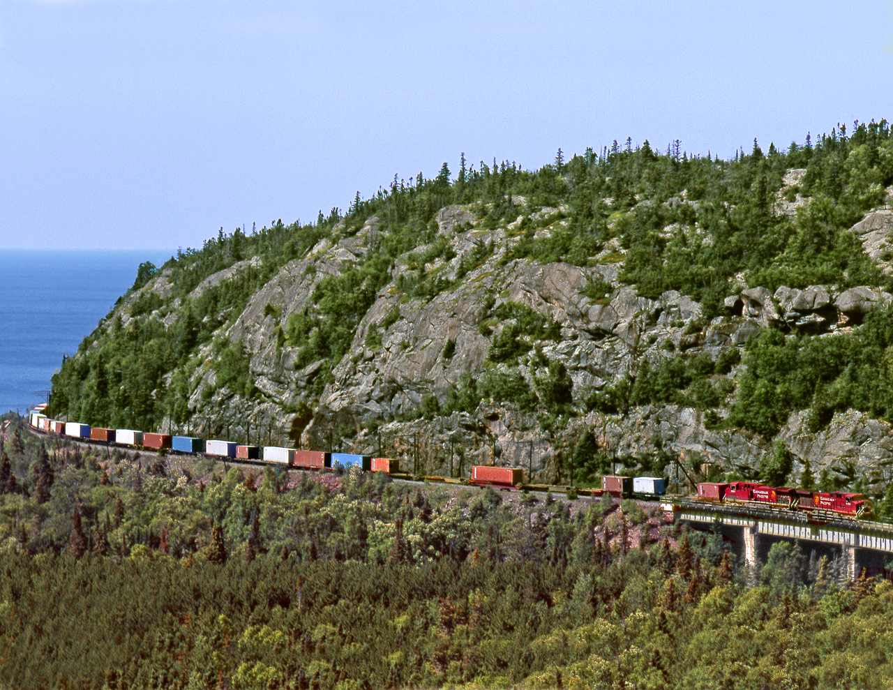Eastbound container train approaches the Little Pic River bridge on Lake Superior's north Shore in Neys Provincial Park