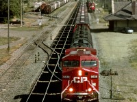 Westbound grain empties pass the 1893 built station while the wayfreight sits in the siding. CN Main and station sits 1/2 block to the right