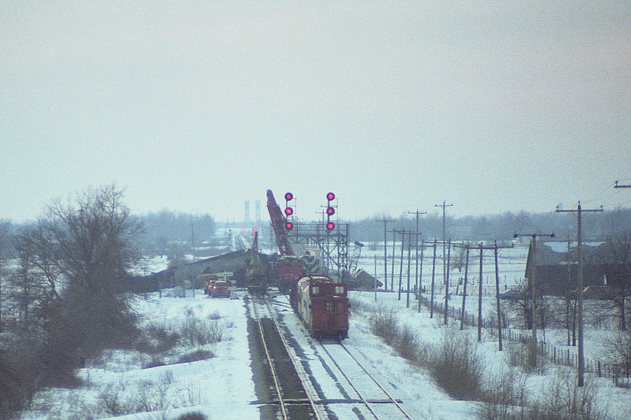 Found this old negative taken off of the Wilhelm Rd overpass of a wreck in which the N&W collided with a CN running same direction, eastward; at a junction on March 1, 1978. (I posted a photo and explanation about 8 years ago; #12614)
One can see the canal bridge in background; and off to the left in front of the pile of twisted rail cars; the "CN Robbins" sign, which managed to survive unscathed. Photo taken at sundown, when I had seen enough.