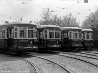 TTC Peter Witt streetcars 2784, 2778, 2714 and 2748 sit in the yard at Russell Carhouse off Queen Street during a Thursday afternoon in May of 1962, awaiting their next call to duty for PM rush hour. Most appear to have come off morning Kingston Road streetcar runs, short-turning or going out of service at Connaught Avenue near the carhouse. One, 2748 parked on the far track of the yard, appears to have carried its last passenger as it's missing its front headlight and rollsigns.<br><br>Overshadowed by more modern PCC streetcars, by this time the old 1920's Peter Witt fleet was not long for this world. The elimination of the Dupont streetcar route that ran on Bay Street the following year (replaced by the new University subway line in February 1963) resulted in the remaining handful of cars being parked and seeing sparse use (often for extra runs, spares, fantrips, charters, etc) until the last one, 2766, was finally retired in June 1965. The TTC would retain and eventually overhaul 2766 for downtown Tour Tram service in the 1970's, and borrow or reacquire a few other cars to join it. Of the four pictured here, 2778 would be sent to Trolleyville in North Olmsted OH when the TTC was in the process of disposing of the last of its cars, and the others were likely sold for scrap.<br><br><i>Original photographer unknown, Dan Dell'Unto collection negative.</i>