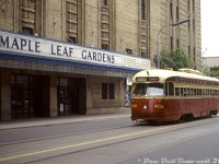 Operating on a May 24th 1987 fantrip around town, chartered TTC PCC 4536 (an A8-class car built in 1951) poses in front of Toronto's downtown hockey shrine: Maple Leaf Gardens. At this time in the 80's, the remaining PCC fleet was on its way out (some like 4536 acquired large inelegant front numbers in their last years) but the TTC was in the early stages of a rebuild program for a handful of their A8 cars, the newest PCC cars in the fleet, for their future downtown Harbourfront route. 4536 would be one of the lucky cars rebuilt, emerging as 4607 in 1990 before the program was cancelled after 19 cars due to new vehicle accessibility requirements. The rebuilt PCC's mainly operated on the 604 Harbourfront route until they were retired and dispersed to other agencies, museums and owners in the mid-90's (4607 was sent to Phoenix AZ).<br><br>Streetcars have trundled along Carlton Street past Maple Leaf Gardens for decades, hauling hockey fans and other event-goers to the Gardens from 1931 until the venue officially closed in 1999 and the Toronto Maple Leafs moved to the new Air Canada Centre. The building was mothballed after, but in the late 2000's a joint partnership between Ryerson University and Loblaws was formed to renovate the old arena into a ground-floor Loblaws grocery store, and Ryerson's Mattamy Athletic Centre (featuring a hockey rink) built above it.<br><br><i>Original photographer unknown, Dan Dell'Unto collection slide.</i>