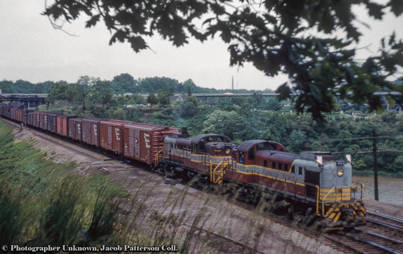 Extra flags flying, TH&B train TF-2, better known as the Starlite, passes through Bayview Junction with a pair of CPR RS3s up front.  Behind the power two freshly painted CPR boxcars head up the freight consist.CPR 8433, built by MLW in 1954, would be chop-nosed in January 1979 and retired December 1982 for scrapping at Angus Shops.  CPR 8453, built by MLW in 1954, would be wrecked near Bedell, ON on the Winchester Sub in January 1974.Original Photographer Unknown, Jacob Patterson Collection Slide.