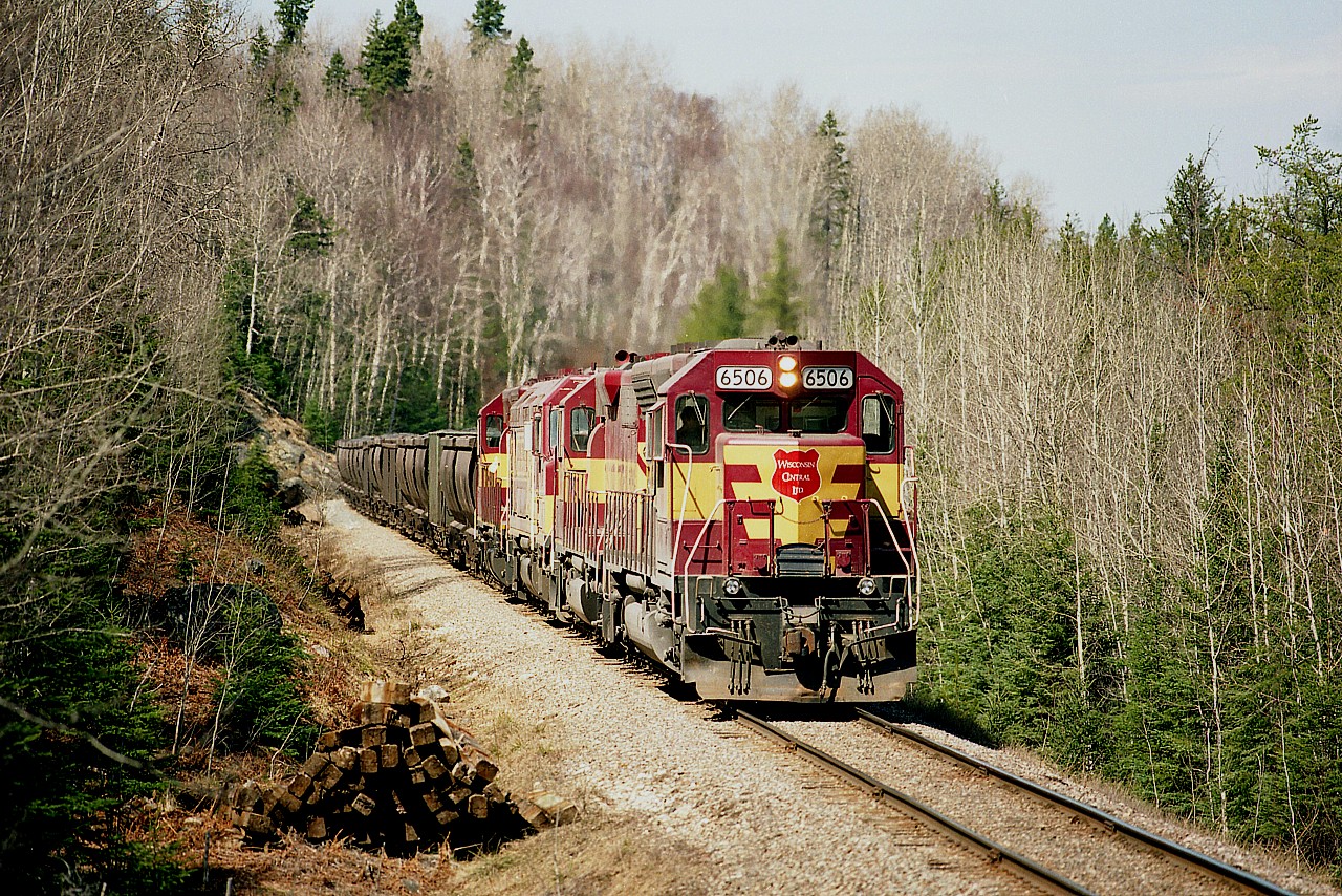 It was only a matter of weeks before the Sinter plant in Wawa, the town's chief employer, shut down for good. From the plant we see WC 6506, 3012, 6655 (SD45) and 6604 coming down off the Michipicoten Sub to the SOO sub at Hawk Jct's station. Pollution at the plant was extremely damaging to a narrow but lengthy band of forest land which was in the path of the winds. Economics dictated the plant shut down mid 1998 and the track all removed by 2000. Wawa really doesn't seem to have recovered.