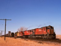 Coalhurst, west of Lethbridge, once was a simple junction of the Aldersyde and Turin subs from the north with the west-east Crowsnest sub., and as such had a small yard and a 24/7 train order office in the depot as shown here beyond the tail end of First 992 (note the green flags) with a pair of M-630s on Wednesday 1974-10-16.  They have just set off the train they brought down from Alyth in Calgary and are headed to Lethbridge.

<p>Nowadays, Kipp yard and maintenance facility occupy the space west and north of this location, replacing the downtown Lethbridge yard and roundhouse area which now has just the relocated through mainline and industrial trackage.