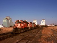 Westward from Lethbridge, train 979 headed with fresh crews at Crowsnest and Cranbrook through to the Union Pacific at Kingsgate/Eastport, shown here approaching the Macleod sub. (now removed) junction at Fort Macleod, with a trio of SD40-2s 5608 + 5643 + 5639 for power.  As may well be imagined, three of those four grain elevators (except the nearest one) are now history.